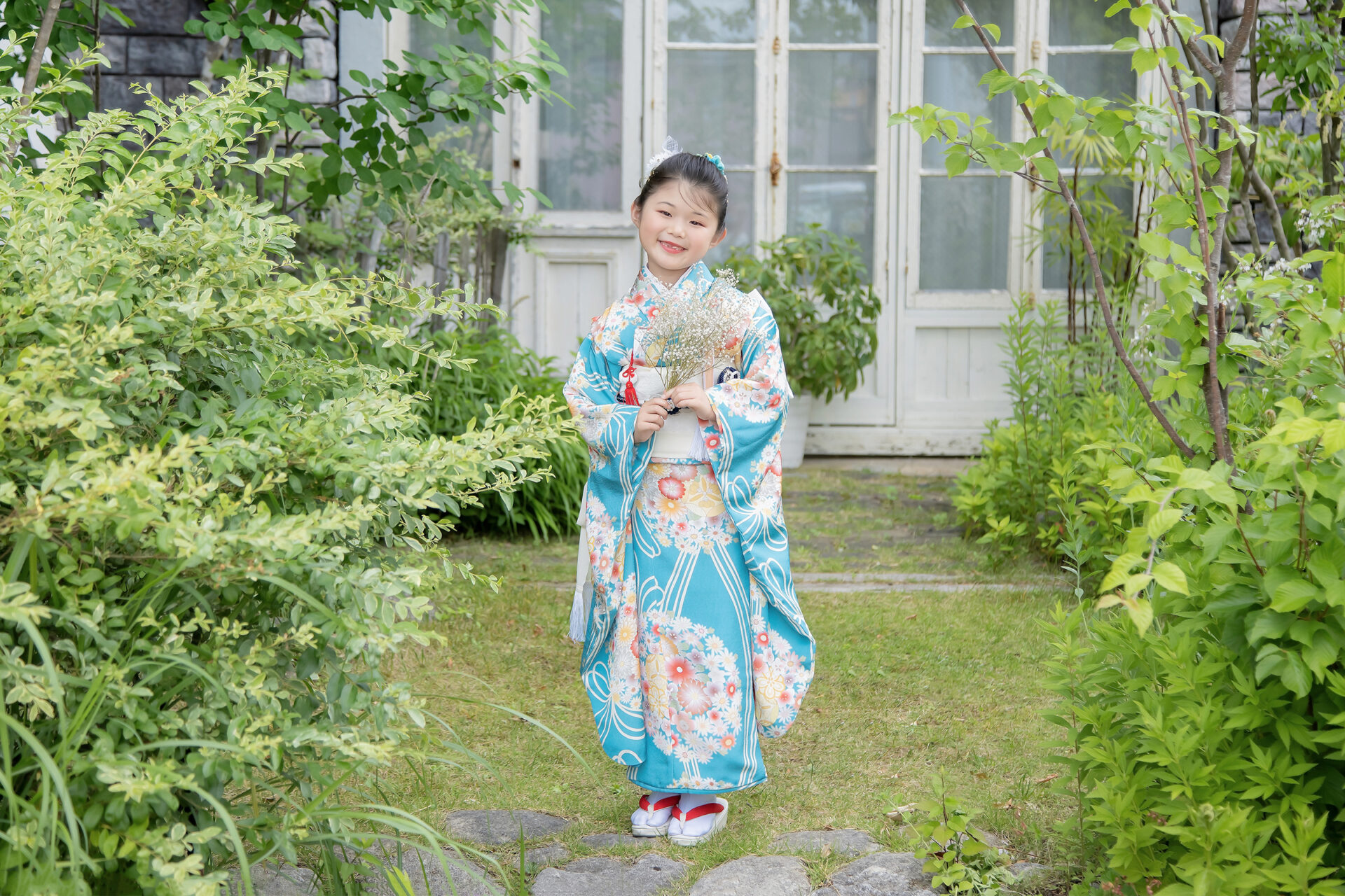 スタジオヨシダラボのガーデンで、自然光の中で七五三撮影をしている子どもの姿