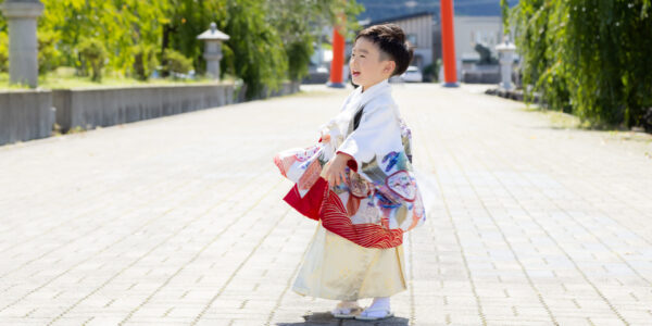 七五三の着物を着た子どもが笑顔で立っている様子